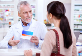 male pharmacist talking to female customer